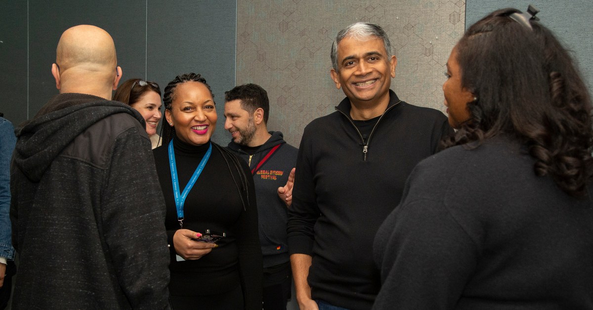Genise Dawson and Rajesh laughing together with colleagues at a company event