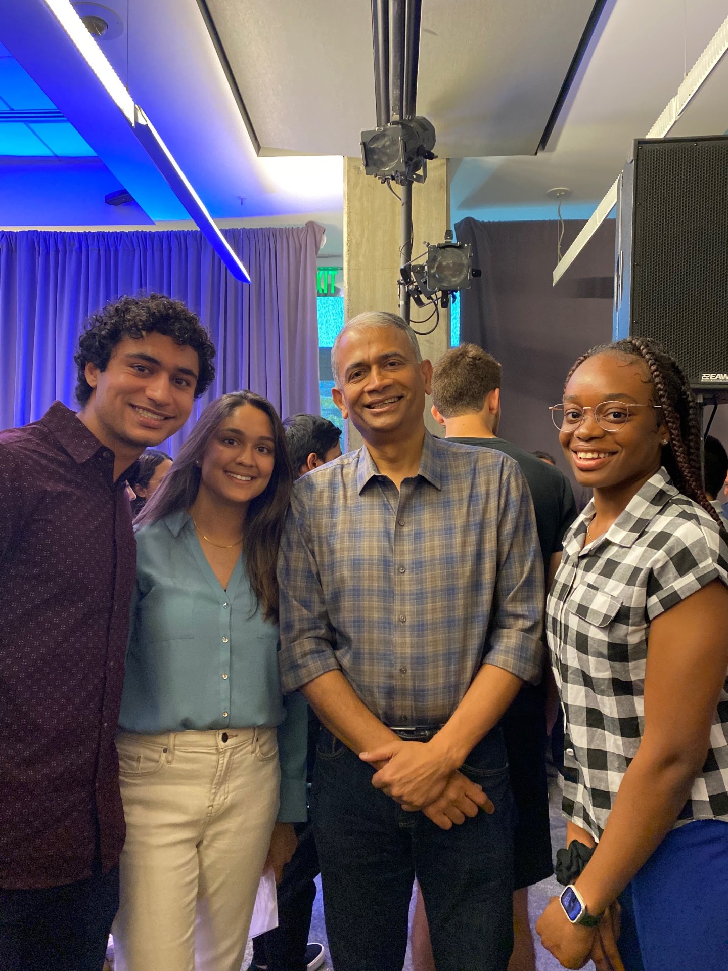 Rajesh posing with three young professionals at an event